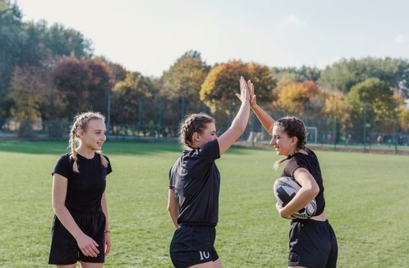 Meninas jogando futebol e comemorando um gol